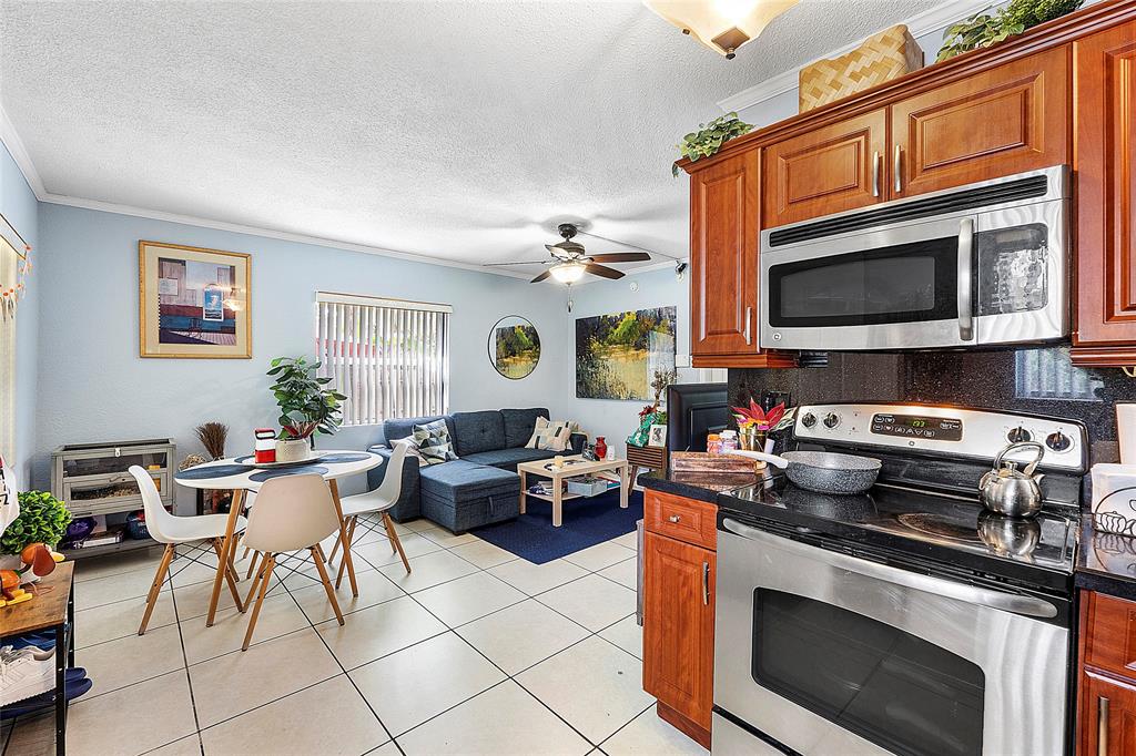 2741 Northeast 8th Avenue, Unit 10 Wilton Manors, FL 33334 - Photo 4 of 28 a kitchen with stainless steel appliances a stove a sink a microwave and dining table