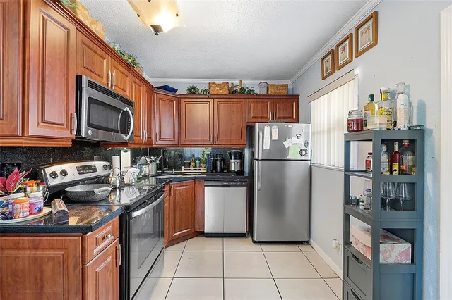 a kitchen with stainless steel appliances granite countertop a refrigerator and a stove top oven