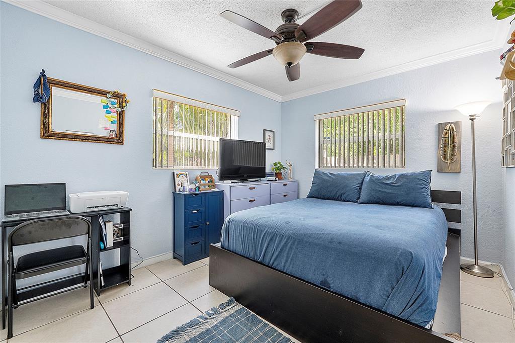 2741 Northeast 8th Avenue, Unit 10 Wilton Manors, FL 33334 - Photo 9 of 28 a bed room with a bed and a chair