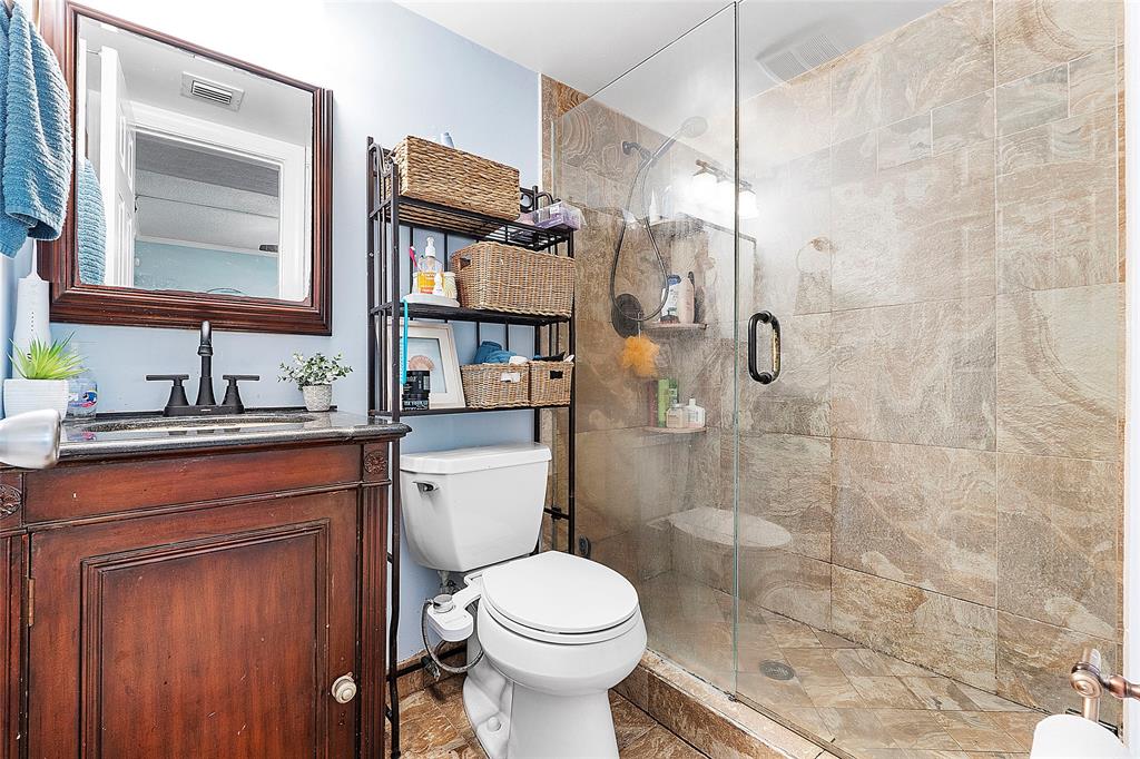 2741 Northeast 8th Avenue, Unit 10 Wilton Manors, FL 33334 - Photo 10 of 28 a bathroom with a granite countertop toilet sink shower and mirror
