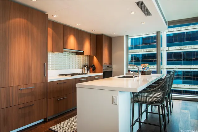 a kitchen with stainless steel appliances granite countertop a stove a refrigerator a dining table and chairs with wooden floor