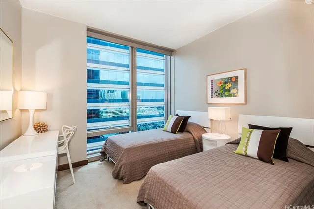 a bedroom with two beds and a large window