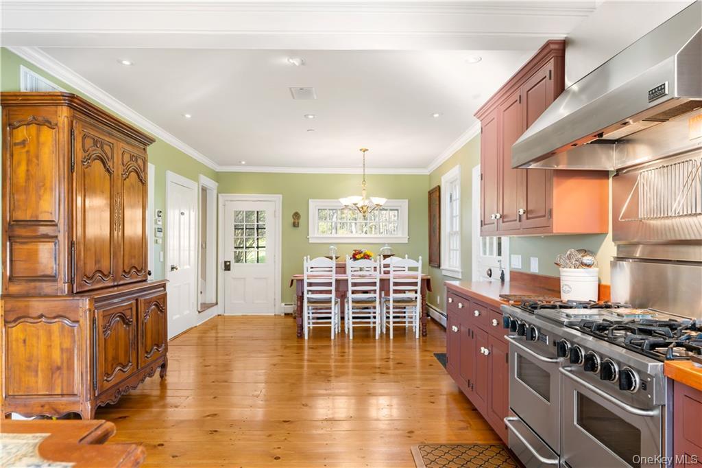 11 Brown Road Pleasant Valley, NY 12569 - Photo 11 of 26 a kitchen with stainless steel appliances granite countertop a stove top oven a sink a dining table and chairs with wooden floor
