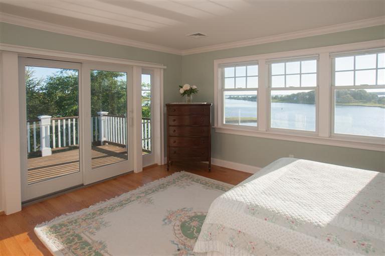 429 Monomoscoy Road Mashpee, MA 02649 - Photo 12 of 26 a bedroom with a large bed and a large window