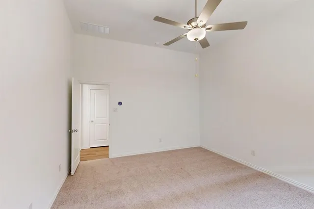 an empty room with a chandelier fan and a chandelier fan
