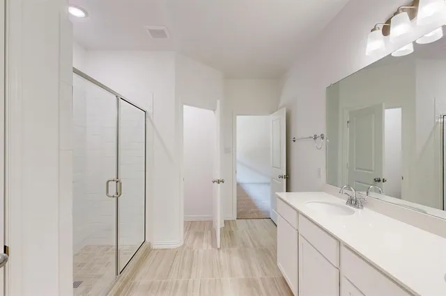 a bathroom with a double vanity sink mirror and shower