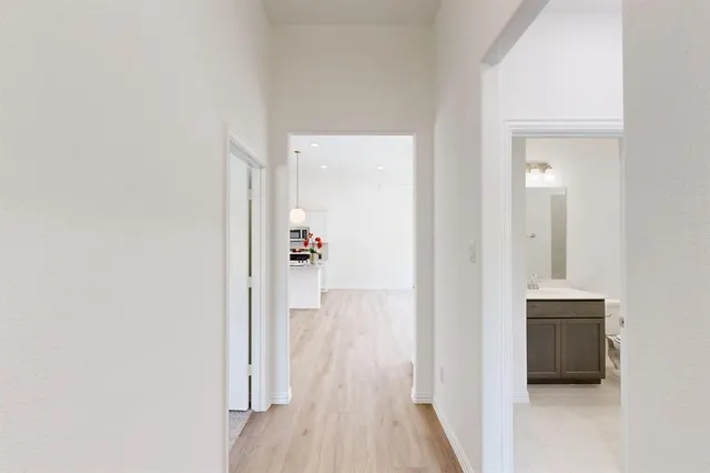 a view of a hallway with wooden floor and staircase