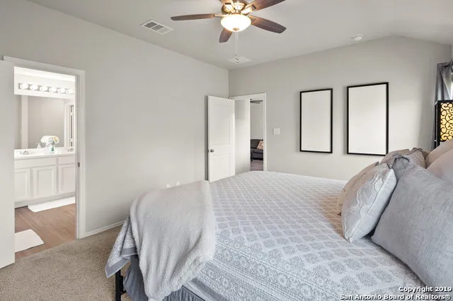a bedroom with a large bed and chandelier