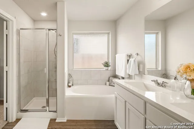 a bathroom with a tub sink and mirror