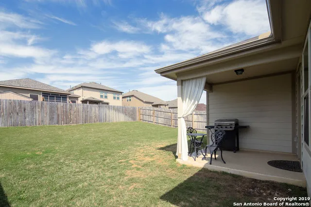 a backyard of a house with table and chairs