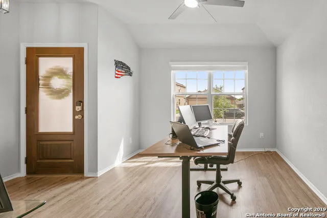 a workspace with wooden floor and a window