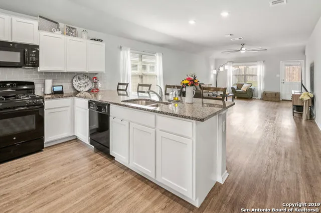 a kitchen with sink a stove and cabinets