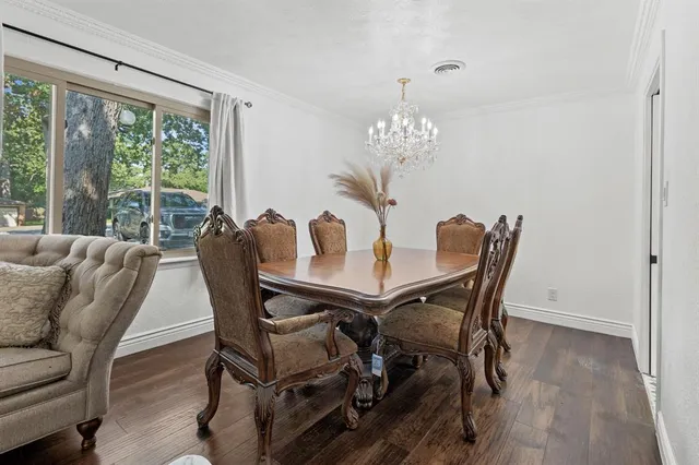 a view of a dining room with furniture a chandelier and wooden floor