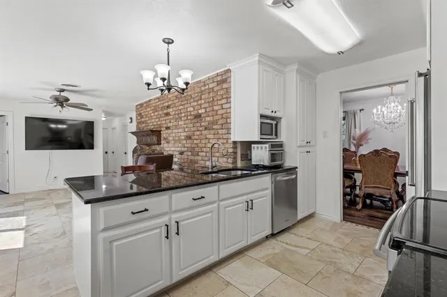 a kitchen with stainless steel appliances granite countertop a sink and a stove