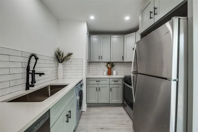 a kitchen with stainless steel appliances a refrigerator sink and cabinets