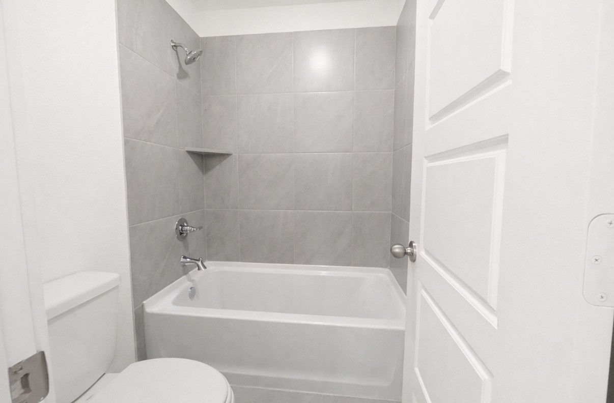 8315 Amber Summit Lane Angleton, TX 77515 - Photo 18 of 21 a white bath tub sitting next to a white toilet