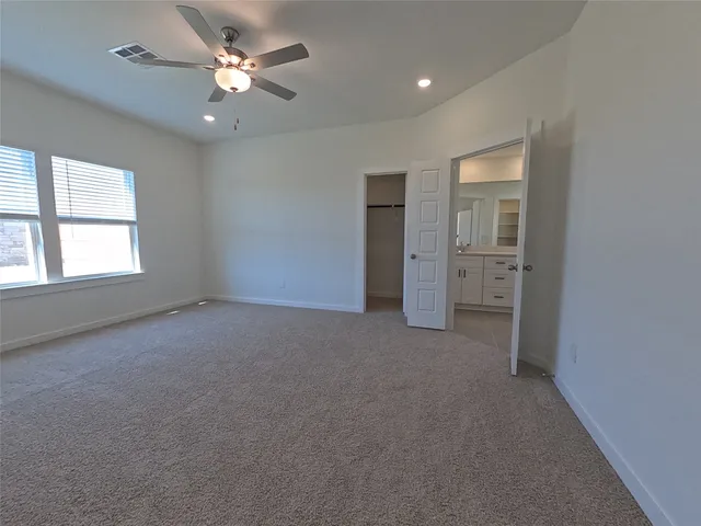 an empty room with a ceiling fan and a window