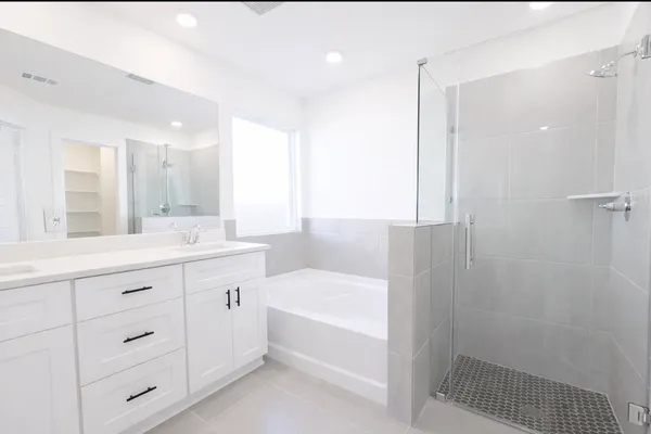 a bathroom with a tub sink and mirror