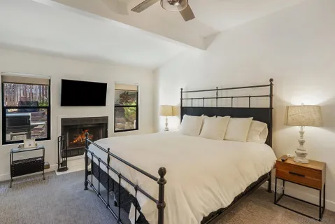 a spacious bedroom with a bed and a flat screen tv
