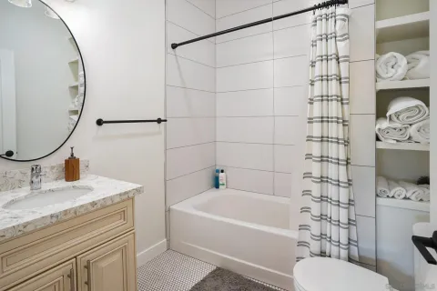 a bathroom with a sink toilet vanity and shower