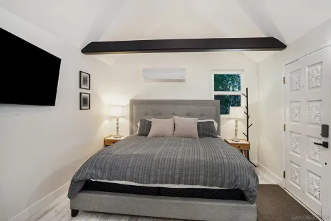 a bedroom with a bed and a flat screen tv