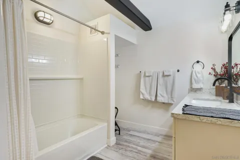a bathroom with a granite countertop sink a toilet and bathtub