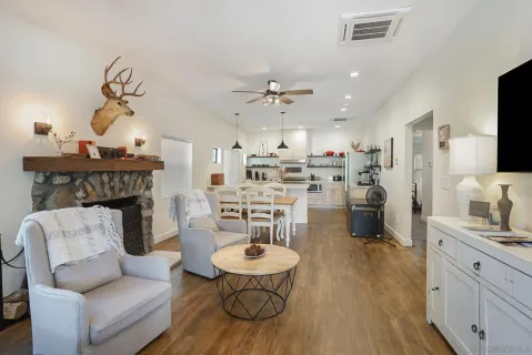a living room with furniture a fireplace and a chandelier