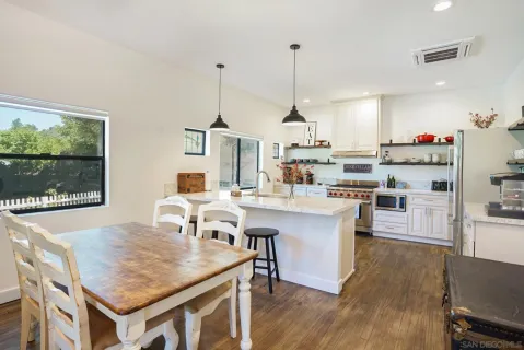 a kitchen with a table chairs and white cabinets