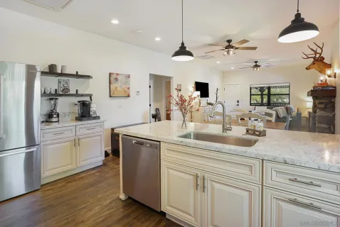a kitchen with kitchen island white cabinets and refrigerator