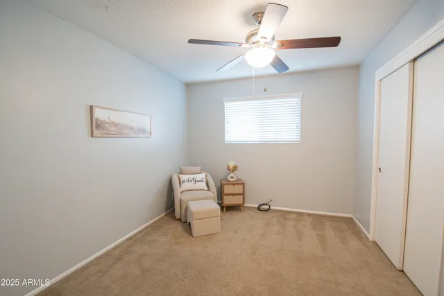 a view of a bedroom with a bed and a ceiling fan