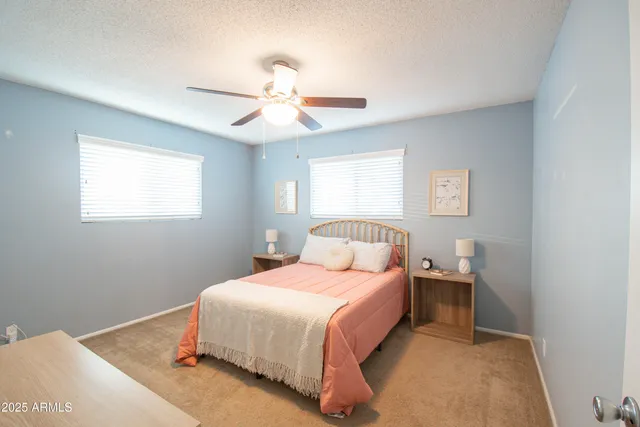 a bedroom with a bed and a ceiling fan