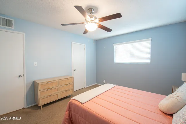 a bedroom with a bed and a ceiling fan