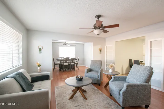 a living room with furniture a table and a large window