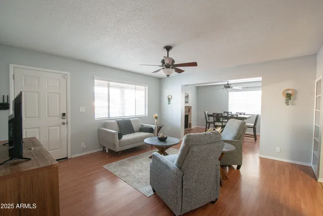 a living room with furniture a flat screen tv and a window
