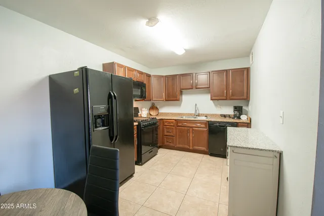 a kitchen with granite countertop a refrigerator and a stove top oven