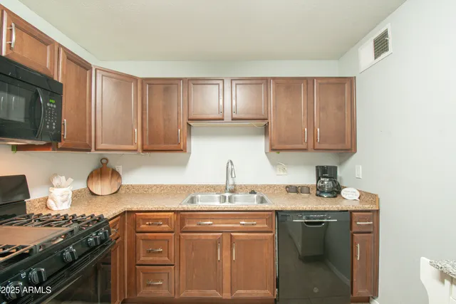 a kitchen with stainless steel appliances granite countertop a sink stove and microwave