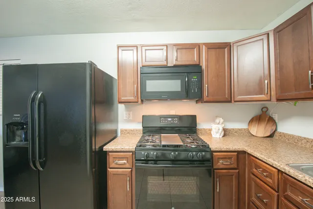 a kitchen with stainless steel appliances granite countertop a refrigerator and a stove top oven