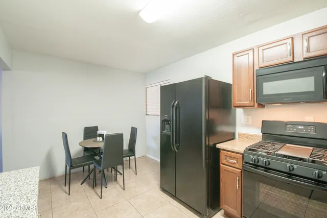 a kitchen with granite countertop a refrigerator and a stove top oven