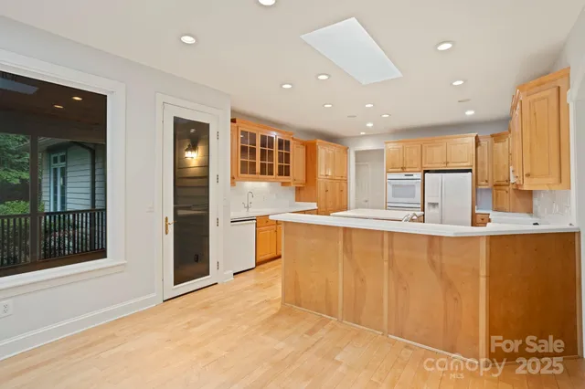 a large kitchen with stainless steel appliances granite countertop a refrigerator and a sink