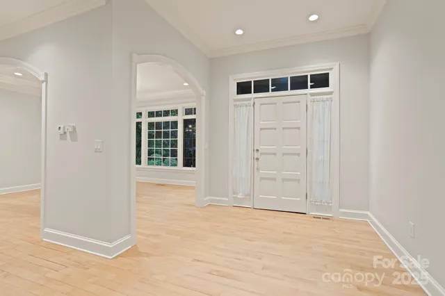 a view of an empty room with wooden floor and windows