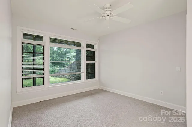 an empty room with windows and cabinet