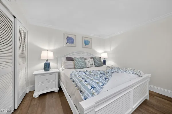 a bedroom with a bed and a painting on the wall