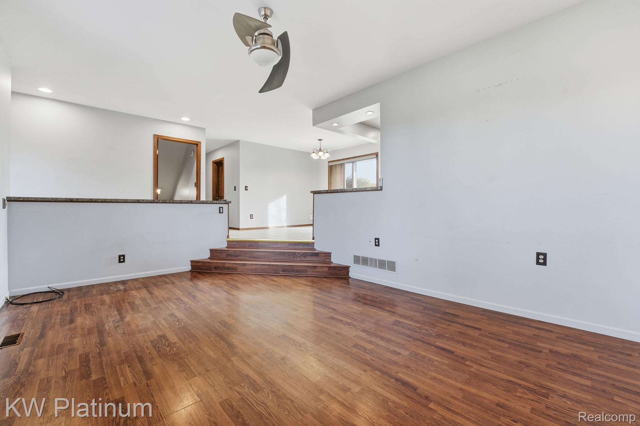 7383 Fisher Road Jeddo, MI 48032 - Photo 4 of 40 Unfurnished room featuring dark wood finished floors, ceiling fan, recessed lighting, and a chandelier