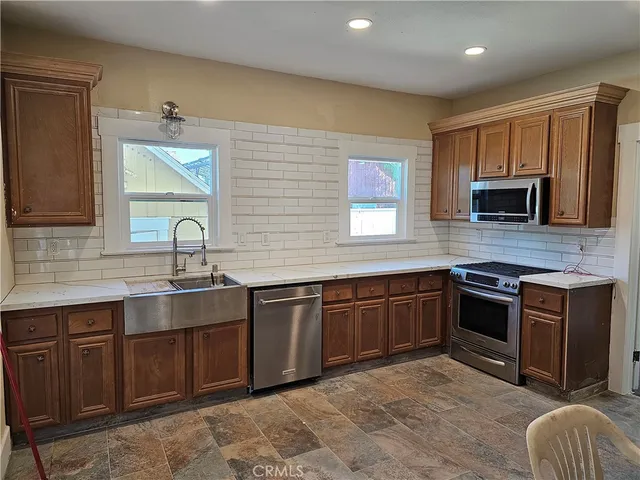 a kitchen with stainless steel appliances granite countertop a sink and stove top oven