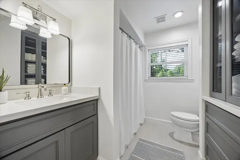 a bathroom with a sink a toilet and a mirror