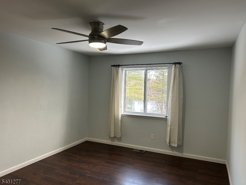2350 State Route 10, Unit 20 Morris Plains, NJ 07950 - Photo 9 of 13 an empty room with wooden floor fan and windows