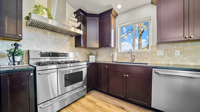 a kitchen with stainless steel appliances granite countertop a stove a sink and a microwave