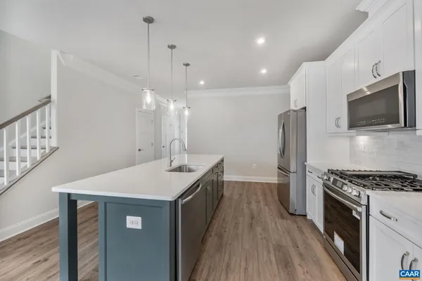 a kitchen with granite countertop a sink a counter space stainless steel appliances and cabinets