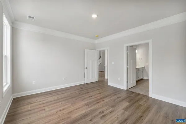 a view of an empty room with wooden floor