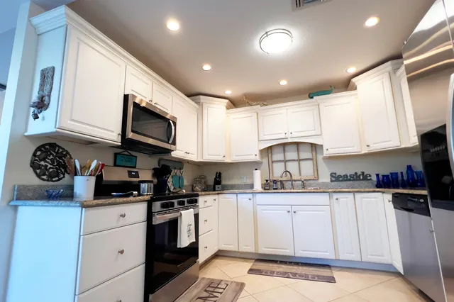 a kitchen with white cabinets and appliances